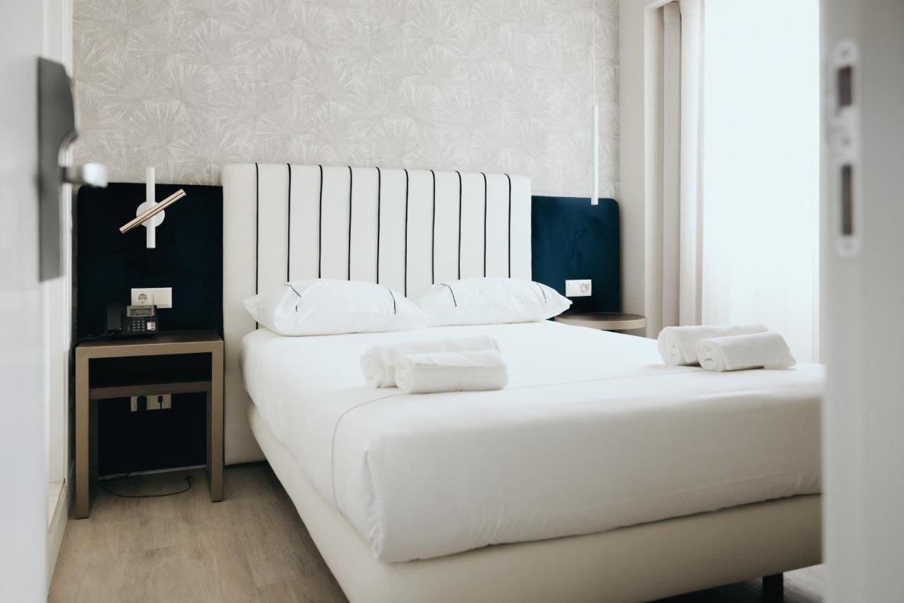 een slaapkamer met een groot wit bed met witte kussens bij M'AR De AR Auria in Lissabon