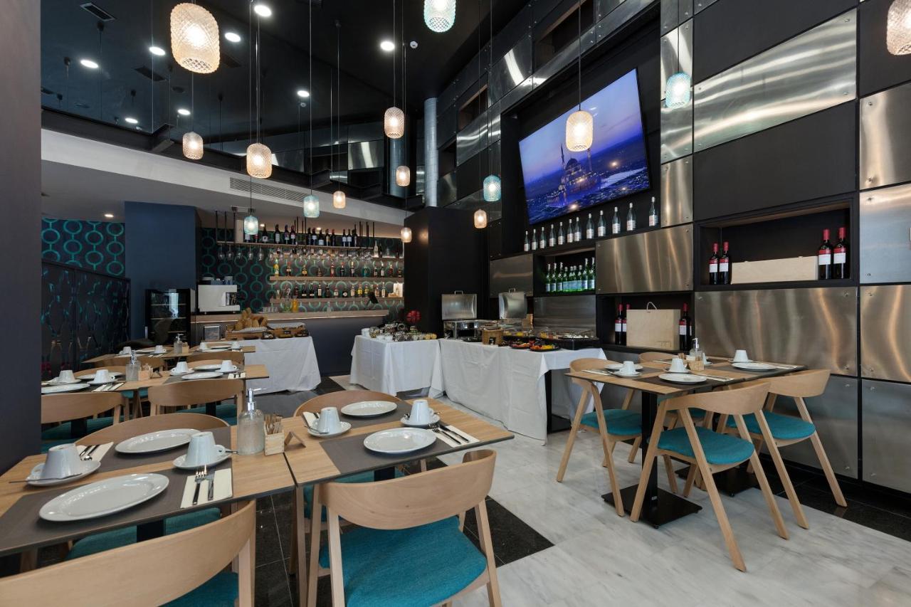 een restaurant met houten tafels en stoelen en een tv bij Trendy Hotel by Athens Prime Hotels in Athene