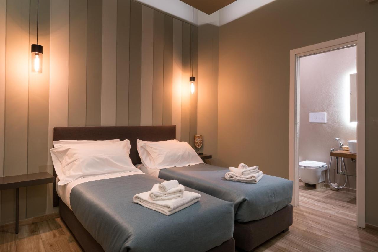 Twee bedden in een kamer met handdoeken erop. bij GOGO` Petit Hotel in Florence