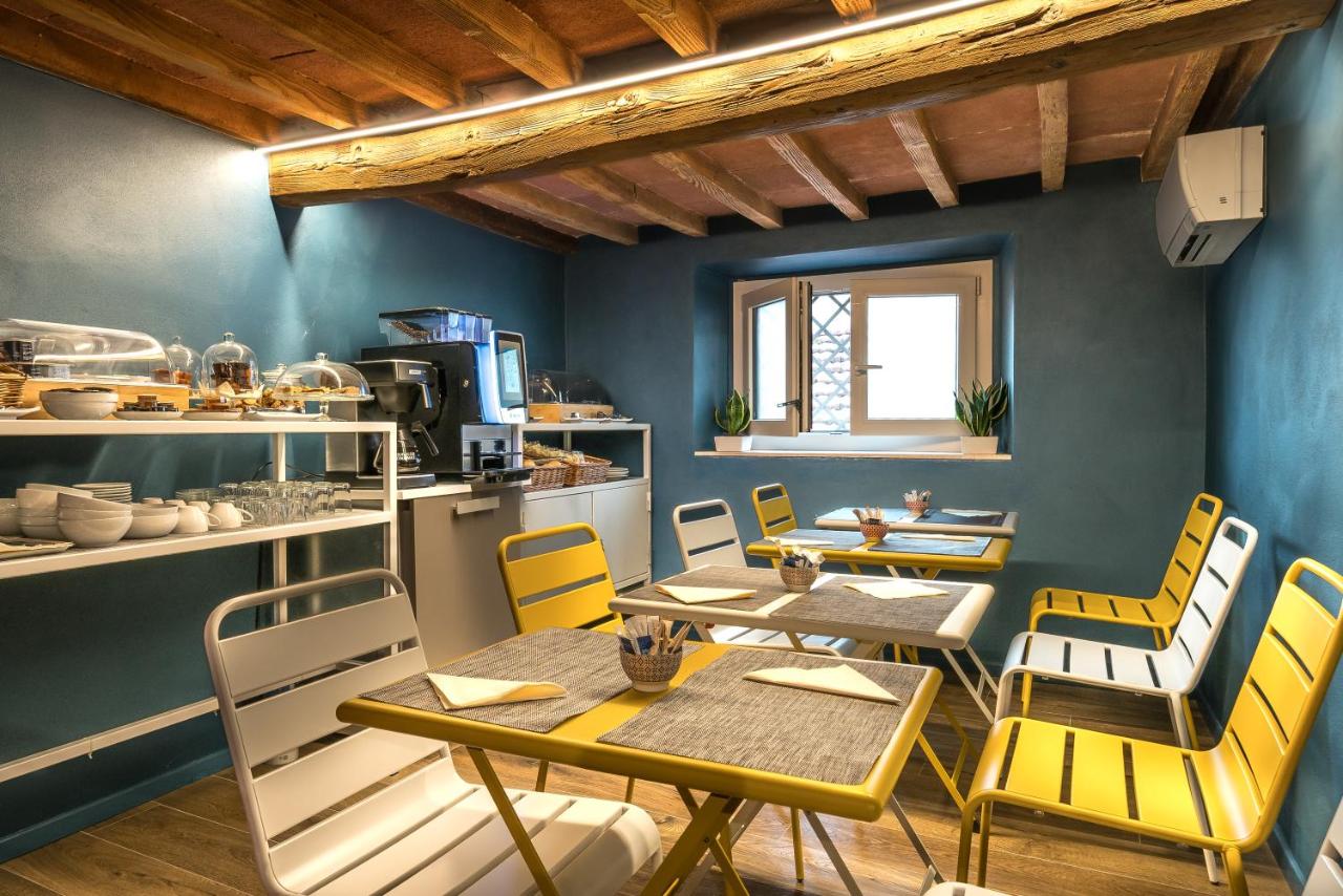 een eetkamer met gele stoelen en tafels bij GOGO` Petit Hotel in Florence