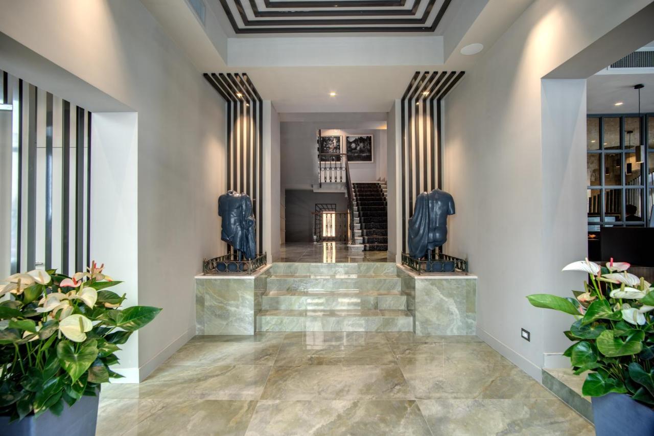 een lobby met een trap met blauwe beelden bij Hotel 77 Seventy-Seven - Maison D'Art Collection in Rome