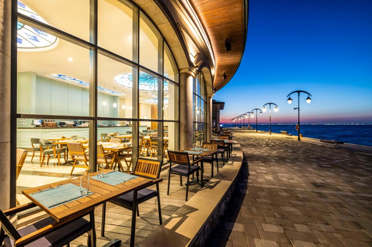 een restaurant met tafels en stoelen en uitzicht op de oceaan bij Birun Ada Hotel in Istanbul