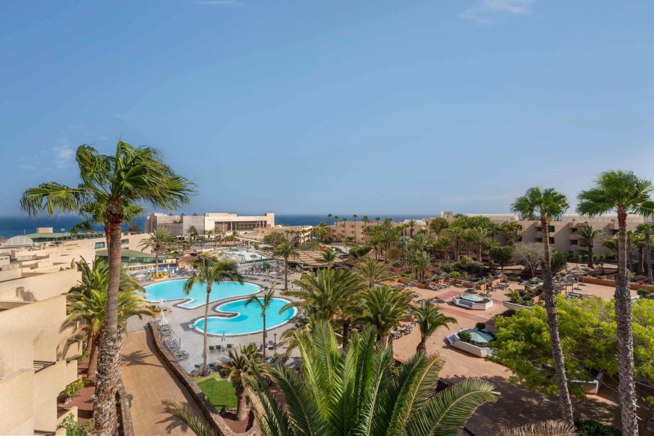Een luchtfoto van een resort met palmbomen en zwembaden. bij Barceló Lanzarote Active Resort in Costa Teguise