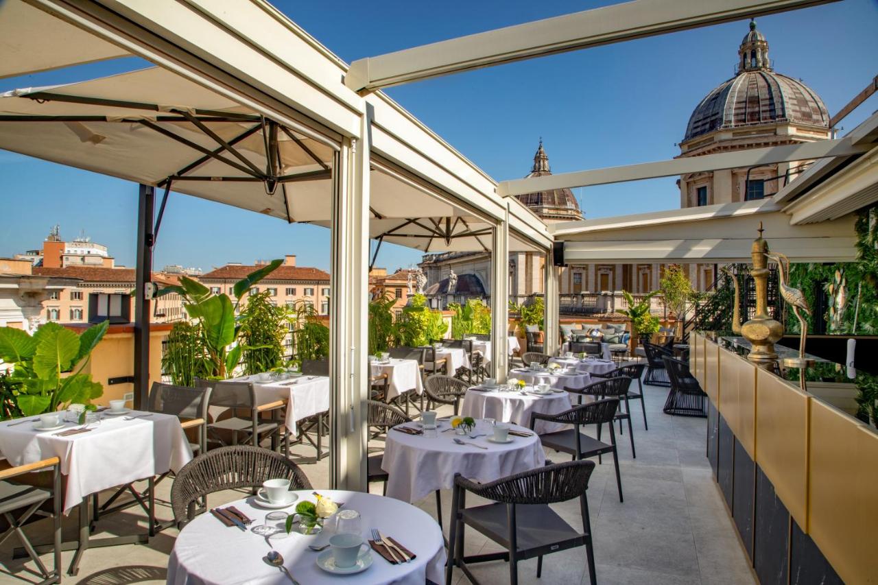 een restaurant met witte tafels en stoelen op een terras bij The Major Hotel in Rome