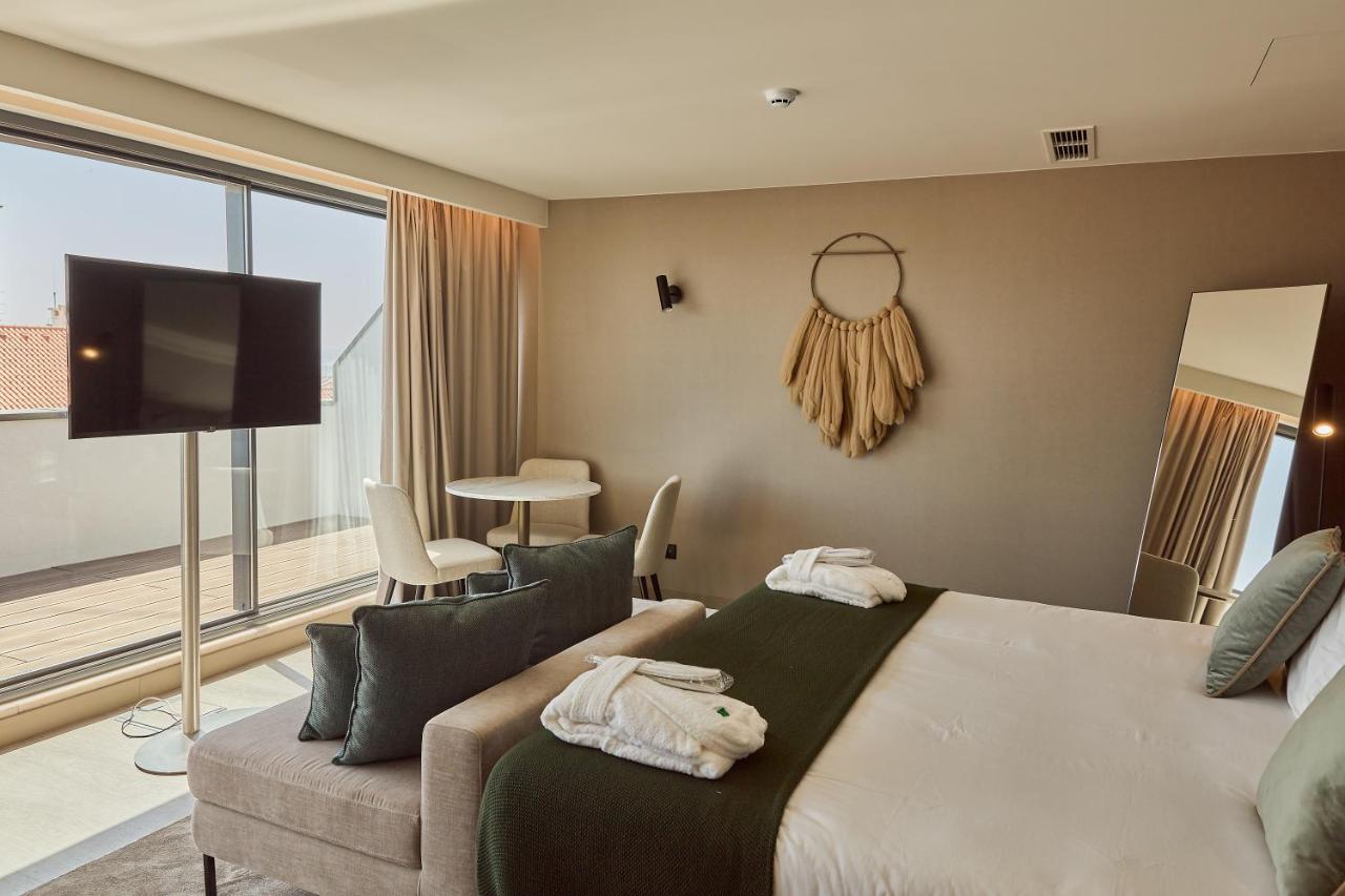 een slaapkamer met een bed, een bank en een tv bij OMID Saldanha Hotel in Lissabon