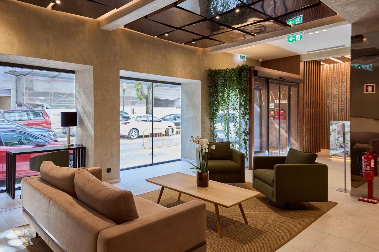 een lobby met een bank, twee stoelen en een tafel bij OMID Saldanha Hotel in Lissabon