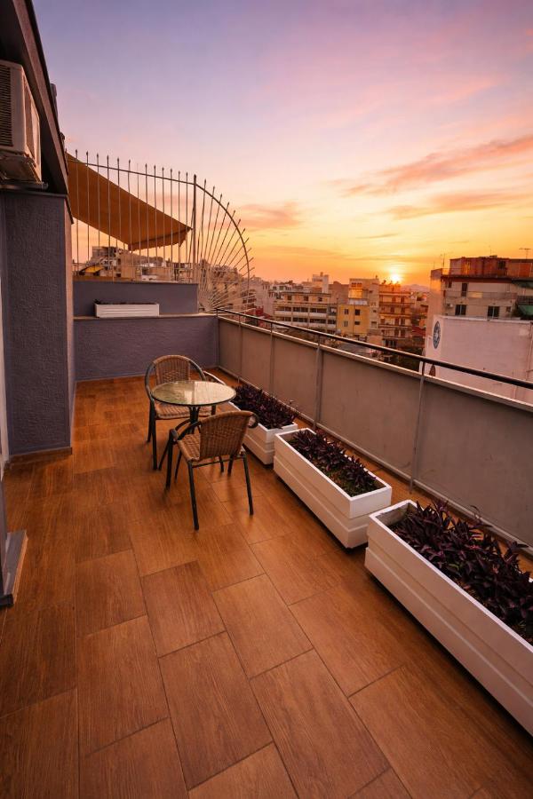 een balkon met een tafel en wat potplanten bij Stalis Hotel in Athene