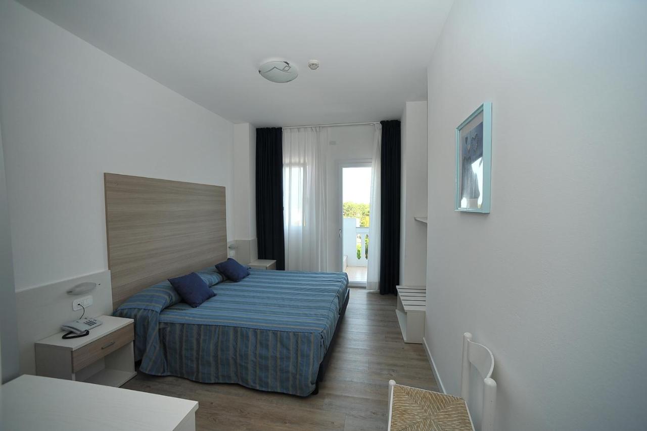 een slaapkamer met een bed met blauwe kussens bij Hotel Germania in Bibione