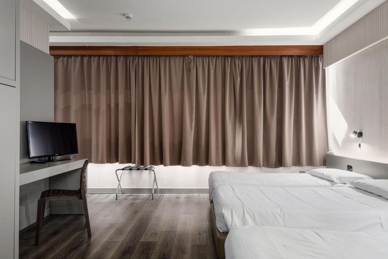 een hotelkamer met twee bedden en een televisie bij The Gate Hotel - Firenze Nord in Sesto Fiorentino
