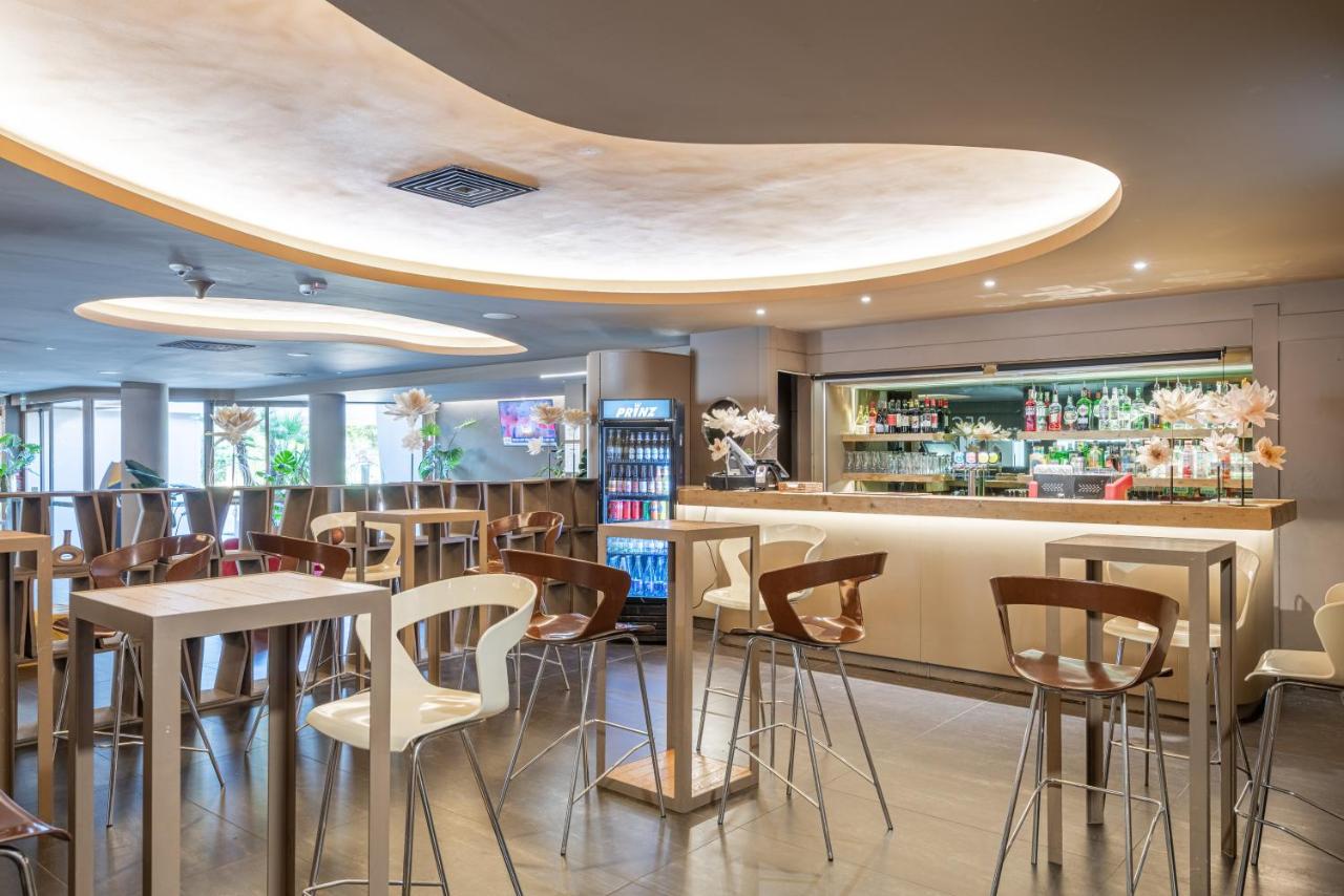 een restaurant met een bar met barkrukken bij The Gate Hotel - Firenze Nord in Sesto Fiorentino