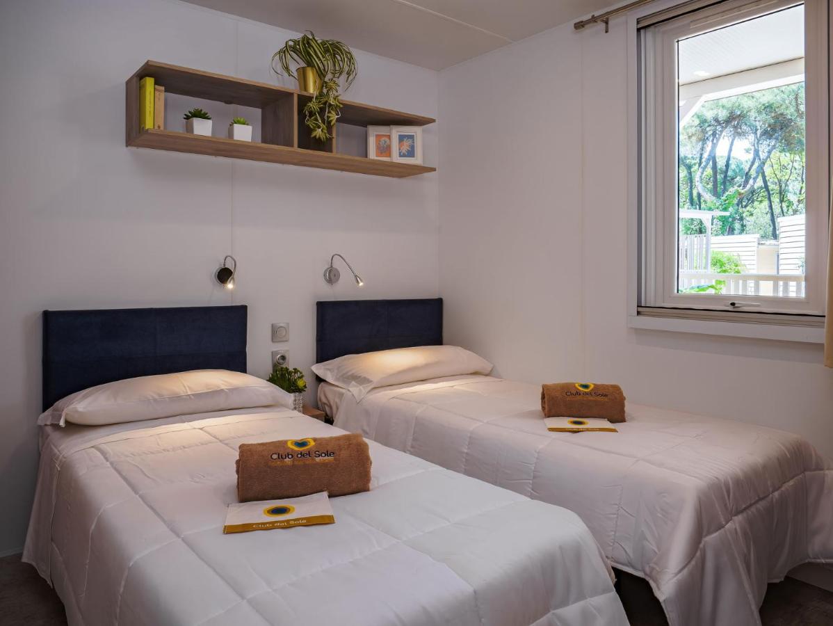 drie bedden in een kamer met een raam bij Club del Sole Rivaverde Easy Camping Village in Marina di Ravenna