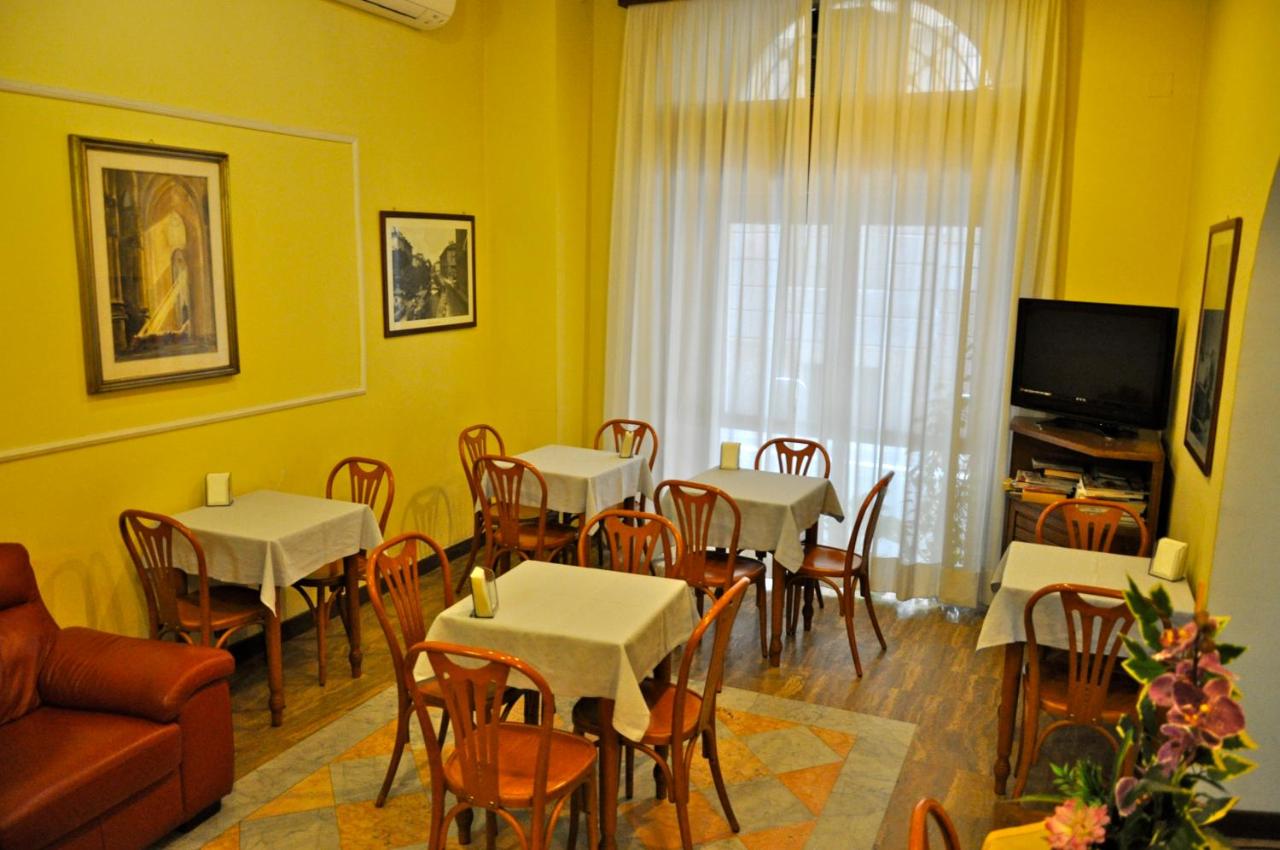 een eetkamer met tafels en stoelen en een tv bij Hotel Vecchia Milano in Milaan