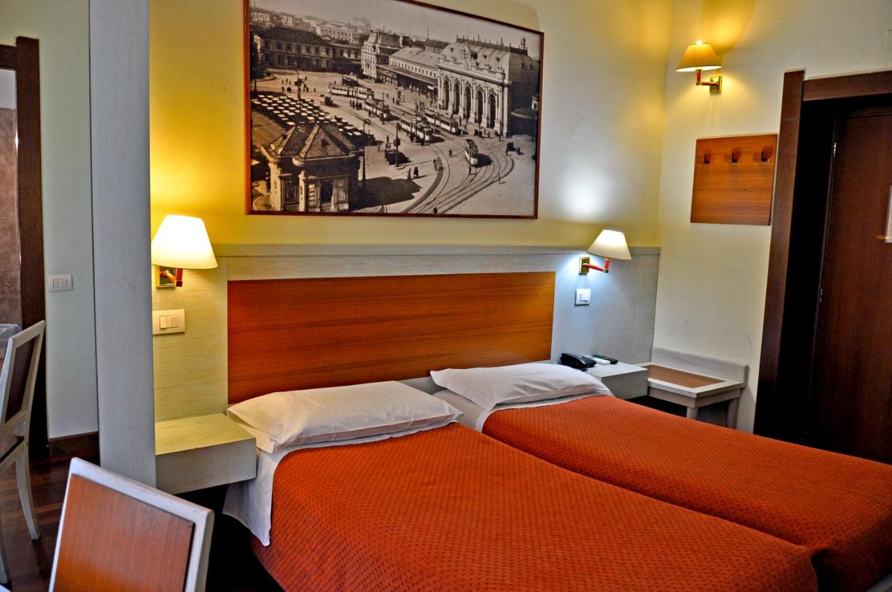 een slaapkamer met een bed met een oranje sprei bij Hotel Rio in Milaan