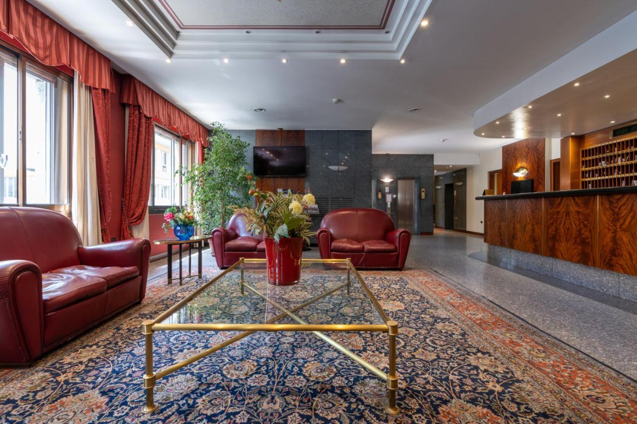 een lobby met rode leren stoelen en een tafel bij Hotel Crivi's in Milaan