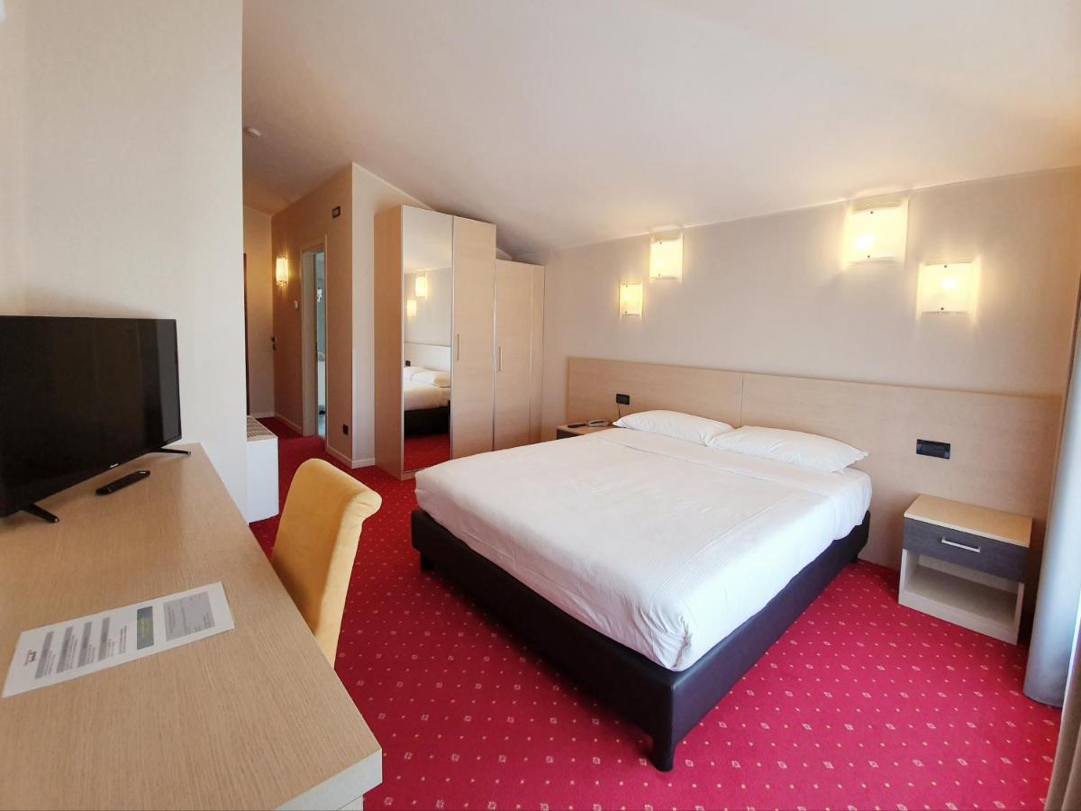 een hotelkamer met een bed en een flatscreen-tv bij Hotel Ristorante al Giardinetto in Colle Umberto