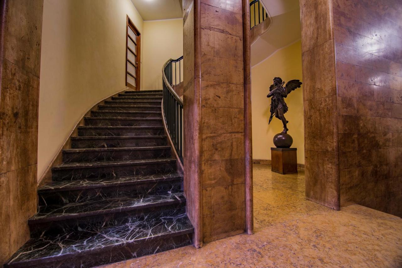 een wenteltrap in een gebouw met een standbeeld bij Luxury Rooms H 2000 Roma in Rome