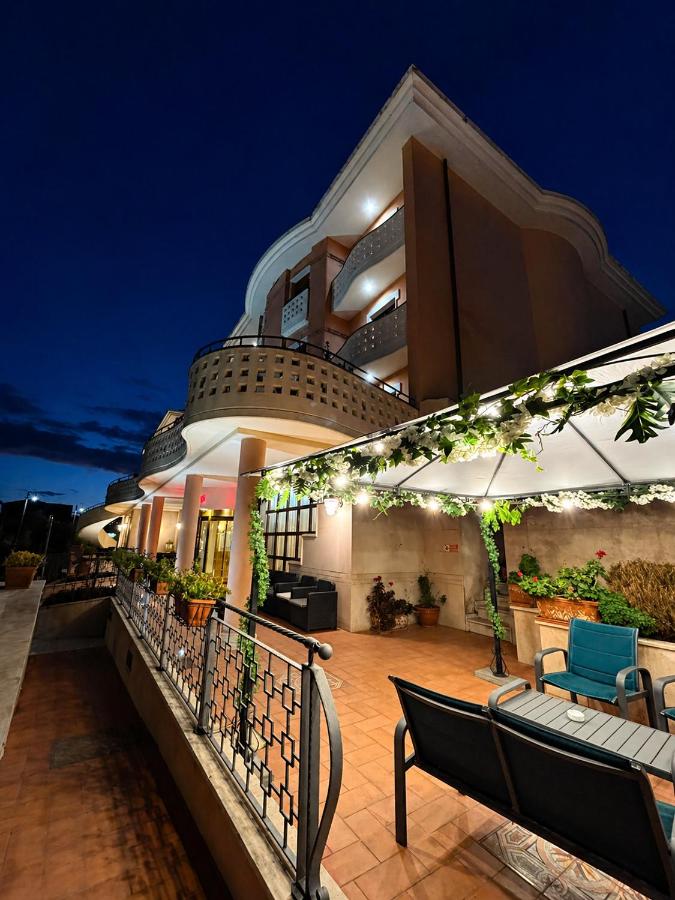 een balkon van een gebouw 's nachts met bankjes bij Hotel Valle Rossa in San Giovanni Rotondo