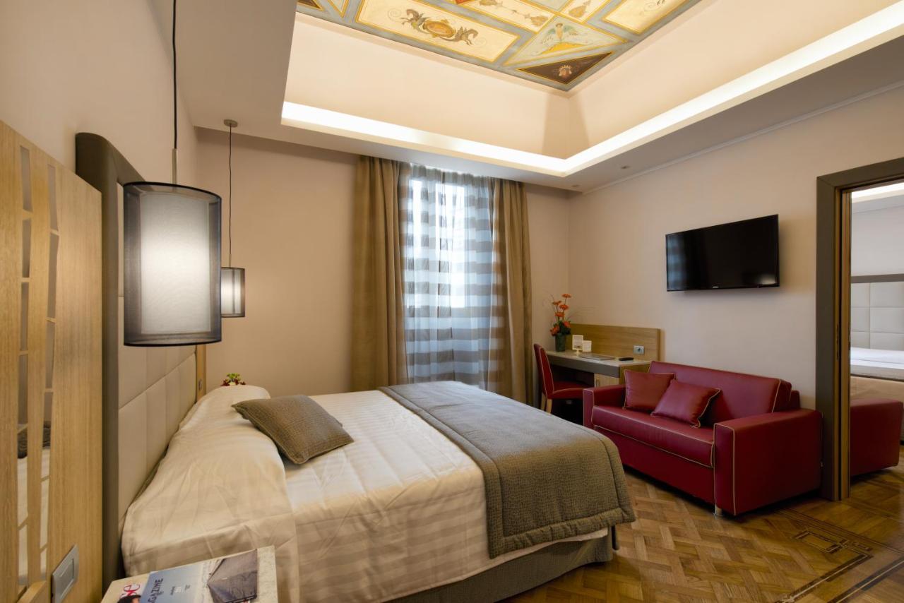 een hotelkamer met een bed en een rode stoel bij Hotel Giolli Nazionale in Rome