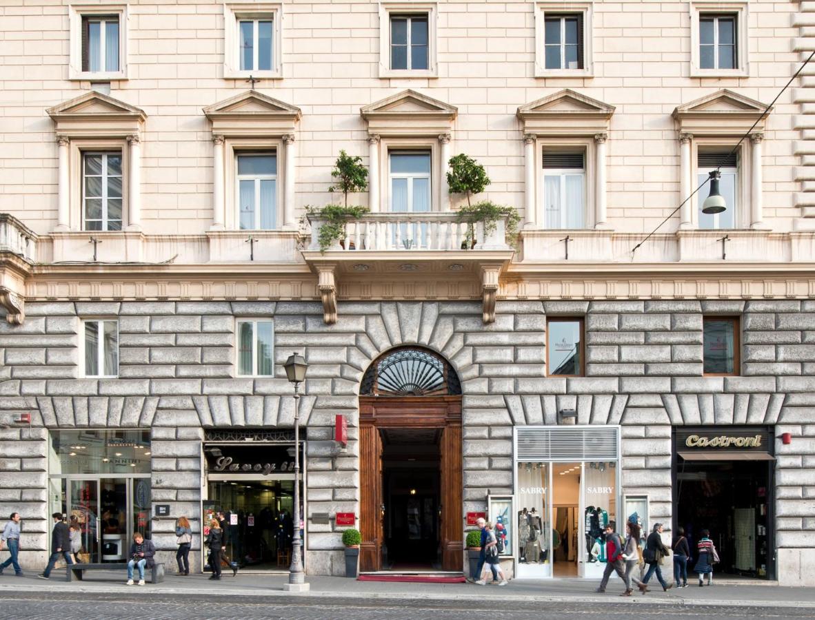 een gebouw met mensen die ervoor lopen bij Hotel Giolli Nazionale in Rome