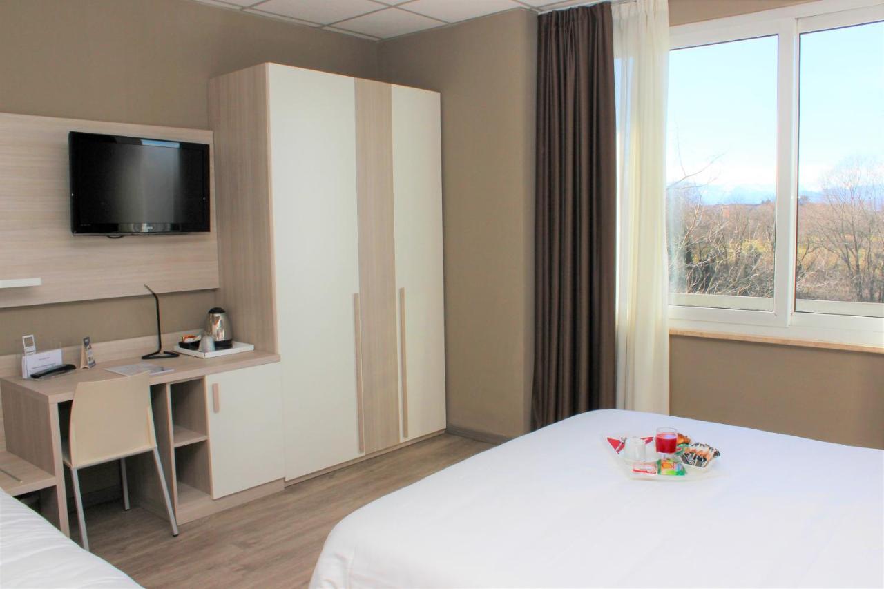 een hotelkamer met een bed, een bureau en een tv bij Best Quality Hotel La Darsena in Moncalieri