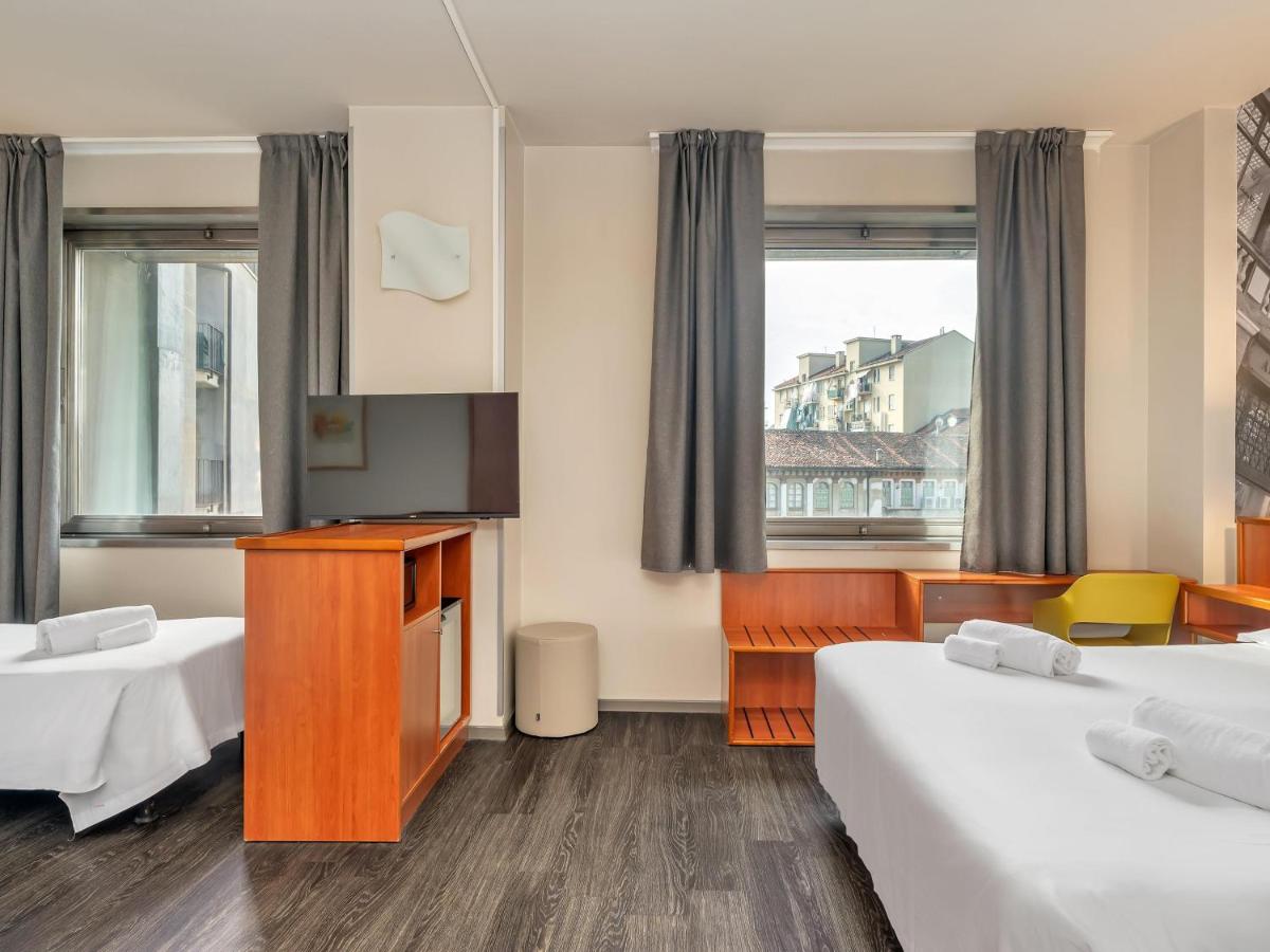 een hotelkamer met twee bedden en een televisie bij B&B Hotel Torino President in Turijn