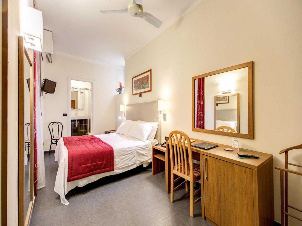 een slaapkamer met een bed, een bureau en een spiegel bij Hotel Giotto Flavia in Rome