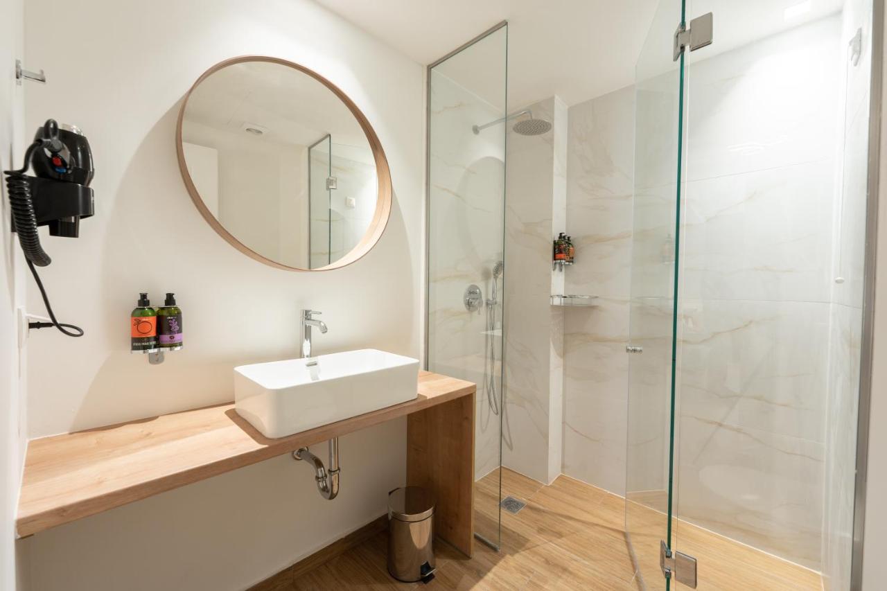 een badkamer met een wastafel en een douche bij Pure Hotel by Athens Prime Hotels in Athene
