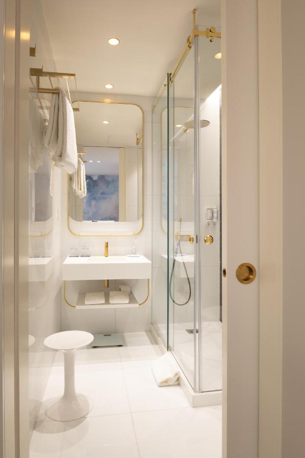 een witte badkamer met een wastafel en een douche bij Blue Liberdade Hotel in Lissabon