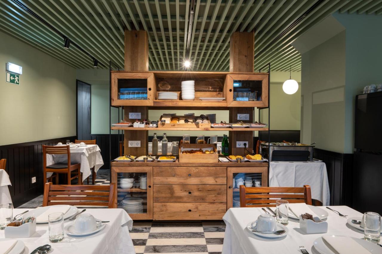 een restaurant met twee tafels en een toonbank met eten bij Blue Liberdade Hotel in Lissabon