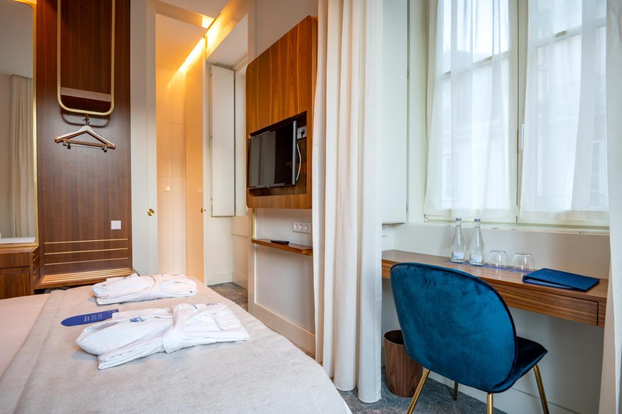 een hotelkamer met een bed en een blauwe stoel bij Blue Liberdade Hotel in Lissabon