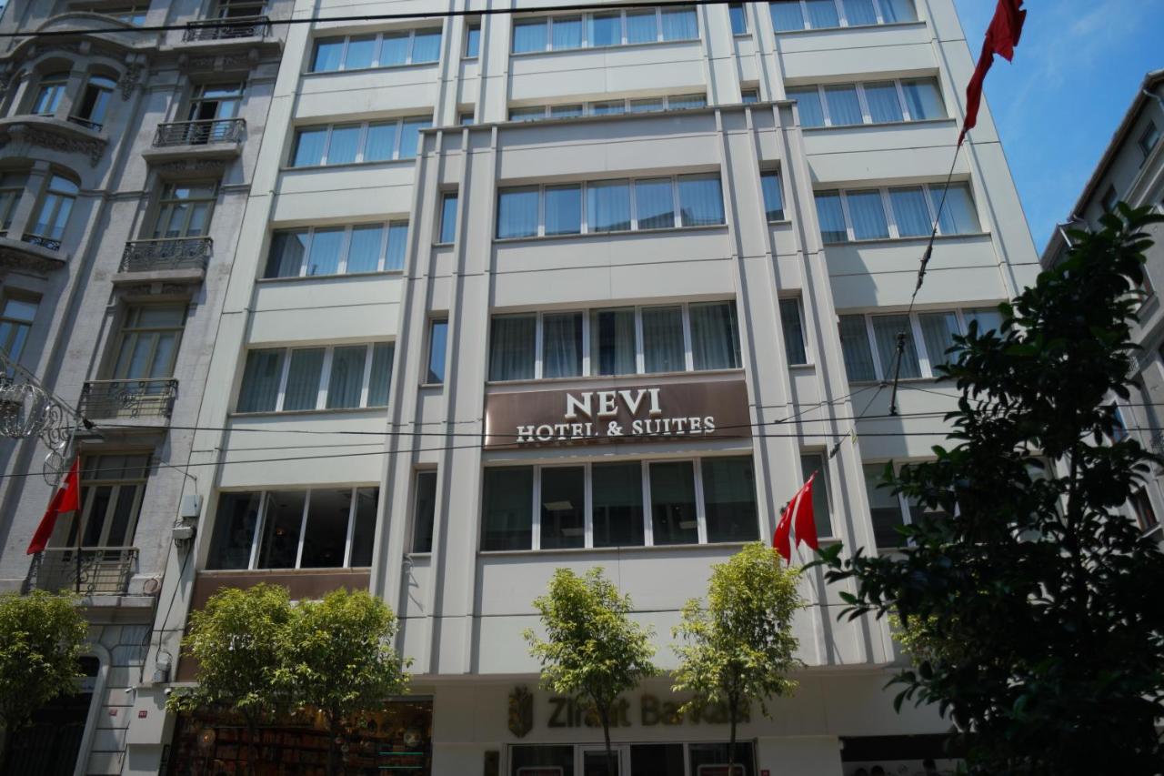 een hoog wit gebouw met een uithangbord bij Nevi Hotel & Suites Istanbul Taksim in Istanbul