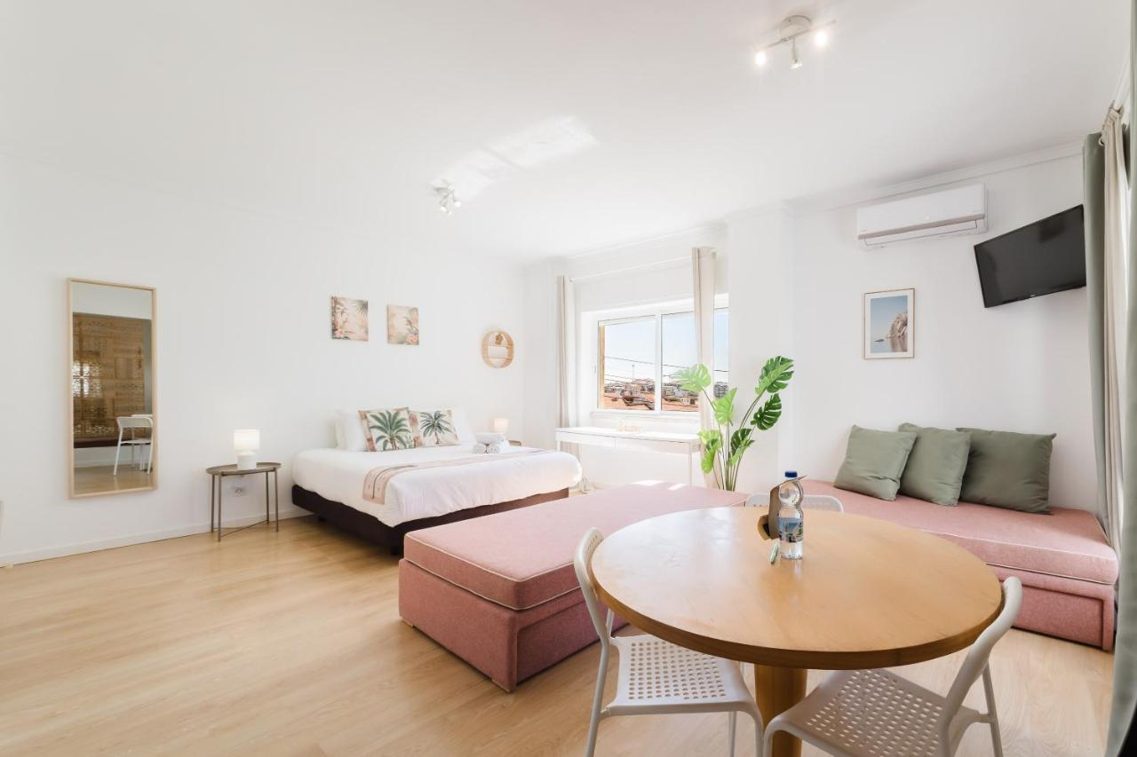een woonkamer met een bank en een tafel bij Villa Paraíso da Caparica in Charneca