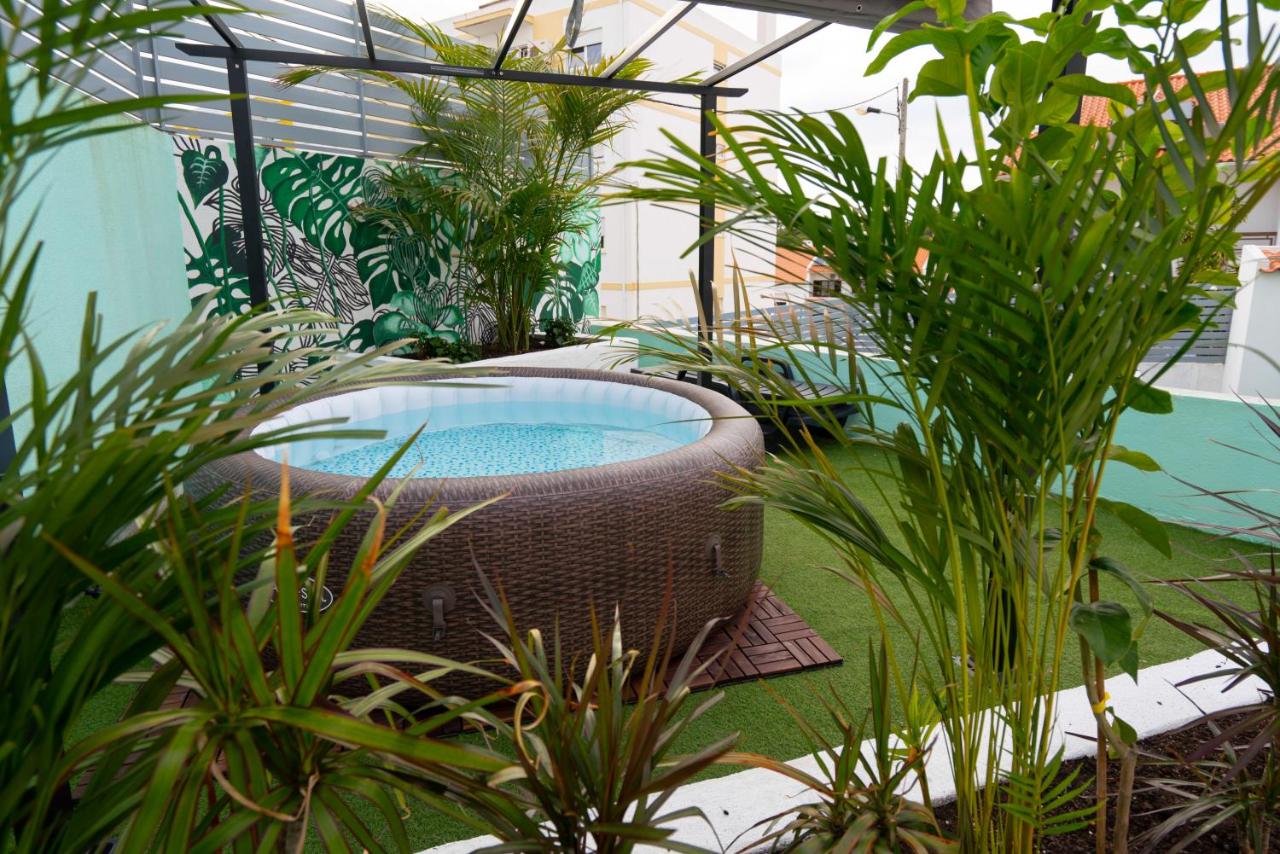 een zwembad in een tuin met planten bij Villa Paraíso da Caparica in Charneca