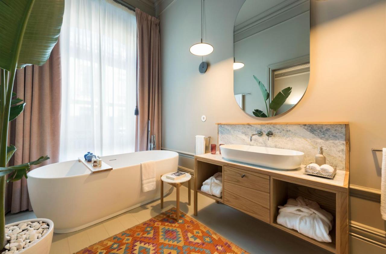 een badkamer met een bad, een wastafel en een spiegel bij Jardins do Porto - by Unlock Hotels in Porto