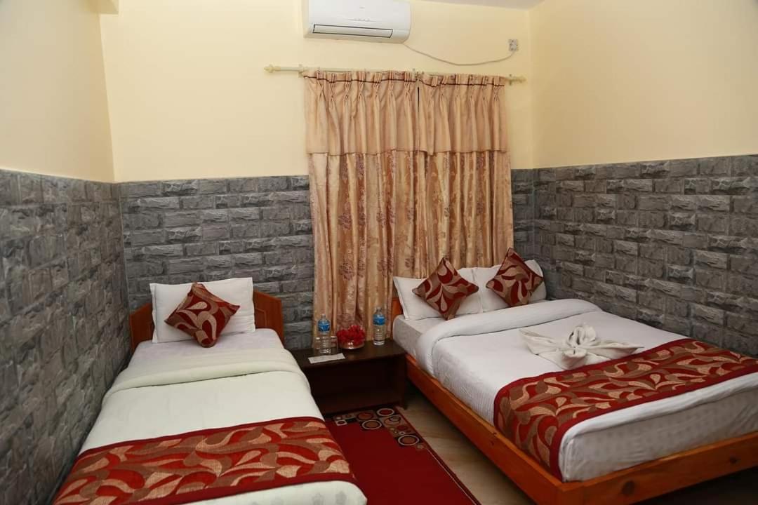 een slaapkamer met twee bedden en een raam bij Hotel Center Inn Lake in Pokhara