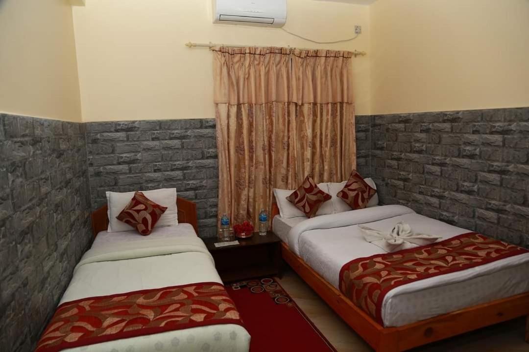 een slaapkamer met twee bedden en een raam bij Hotel Center Inn Lake in Pokhara