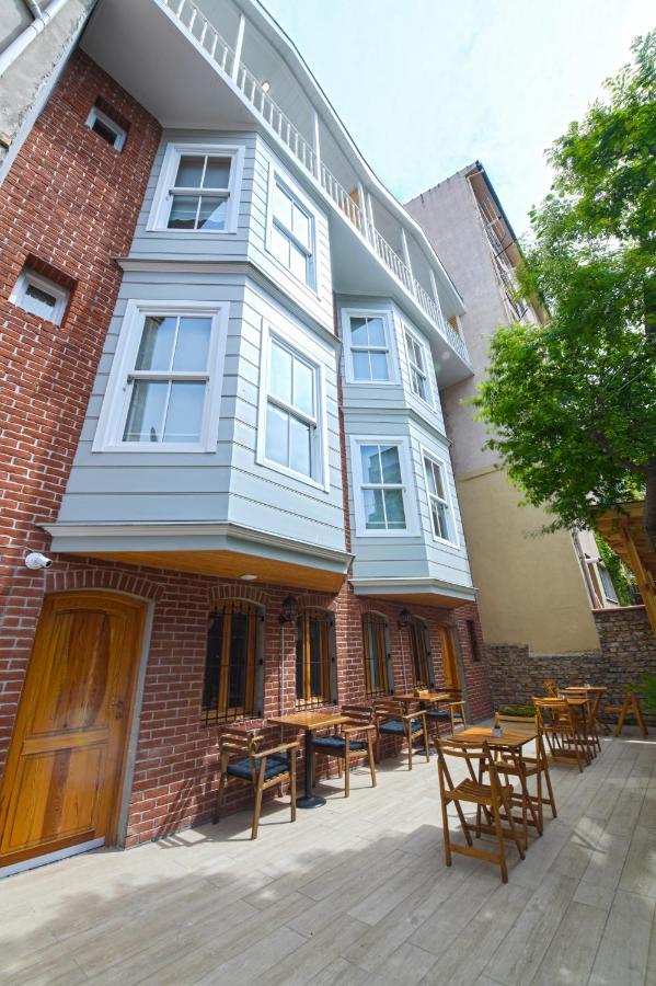 een gebouw met tafels en stoelen ervoor bij İkiz Konak Boutique Hotel in Istanbul
