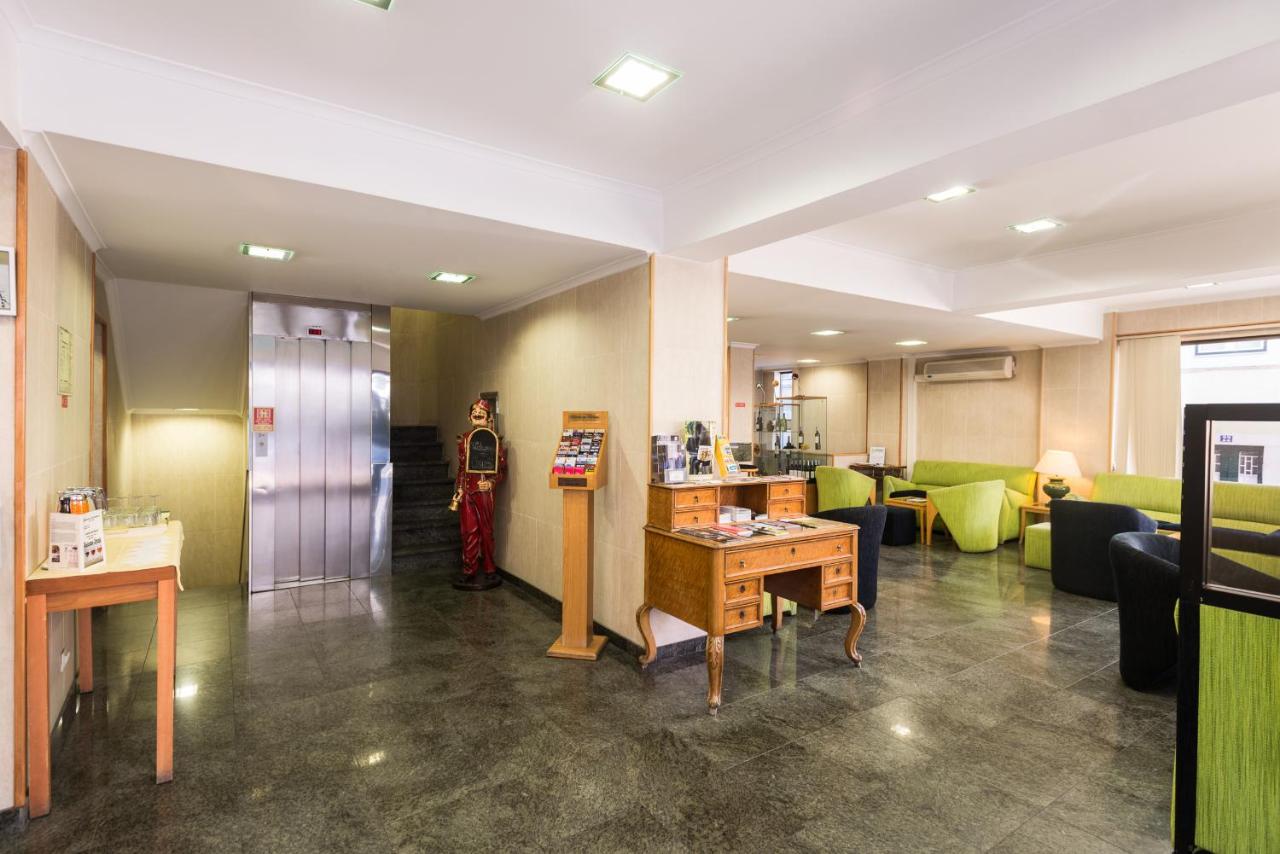 een lobby met een kamer met een tafel en stoelen bij Hotel Botanico in Lissabon