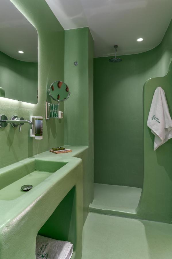 een groene badkamer met een wastafel en een badkuip bij LOFUS Bio-Suites in Athene