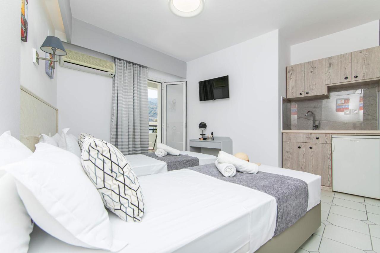 een slaapkamer met twee bedden en een keuken bij ICandy Sol in Malia