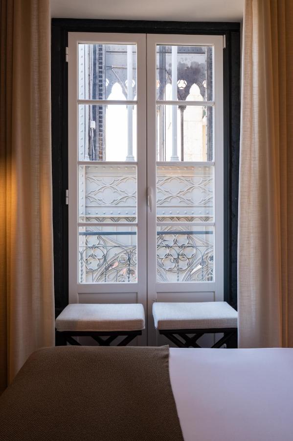 een slaapkamer met een raam met twee stoelen ervoor bij Tempo FLH Hotels Lisboa in Lissabon