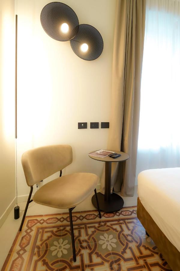een slaapkamer met een bed, een stoel en een tafel bij Bergamo INN 21 in Bergamo