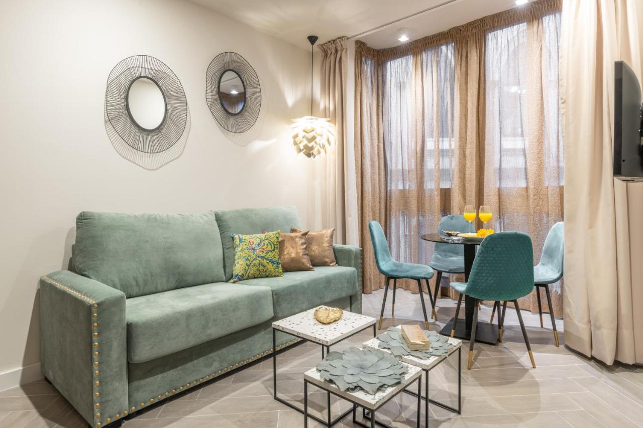 een woonkamer met een groene bank en een tafel bij Spa del Palacete in Málaga