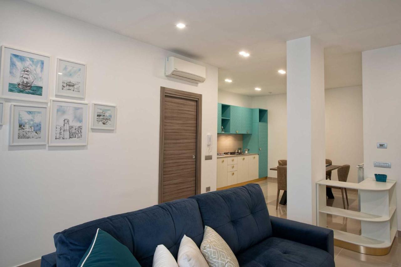 een woonkamer met een blauwe bank en een keuken bij Charme en Bleu in Castellammare di Stabia