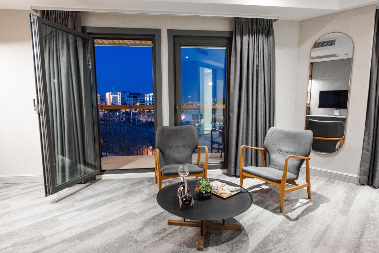 een woonkamer met twee stoelen en een tafel bij Dosso Dossi Hotels Yenikapı in Istanbul
