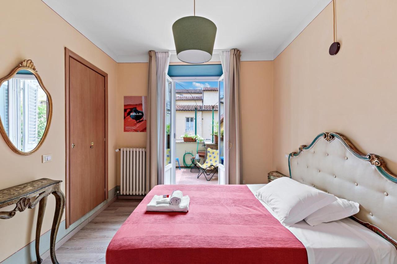 een slaapkamer met een bed met een rode deken bij Ostello Bello Firenze in Florence