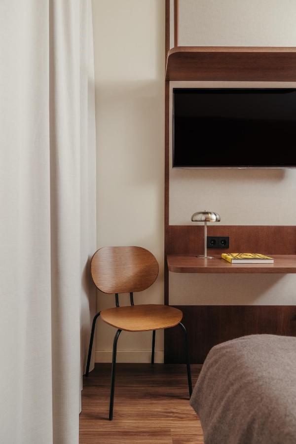 een slaapkamer met een stoel en een bureau met een televisie bij H Regas Adults Only in Barcelona