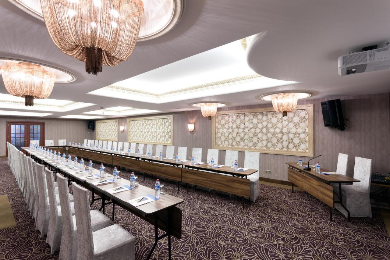 een lange rij tafels in een kamer met kroonluchters bij Grand Anka Hotel in Istanbul