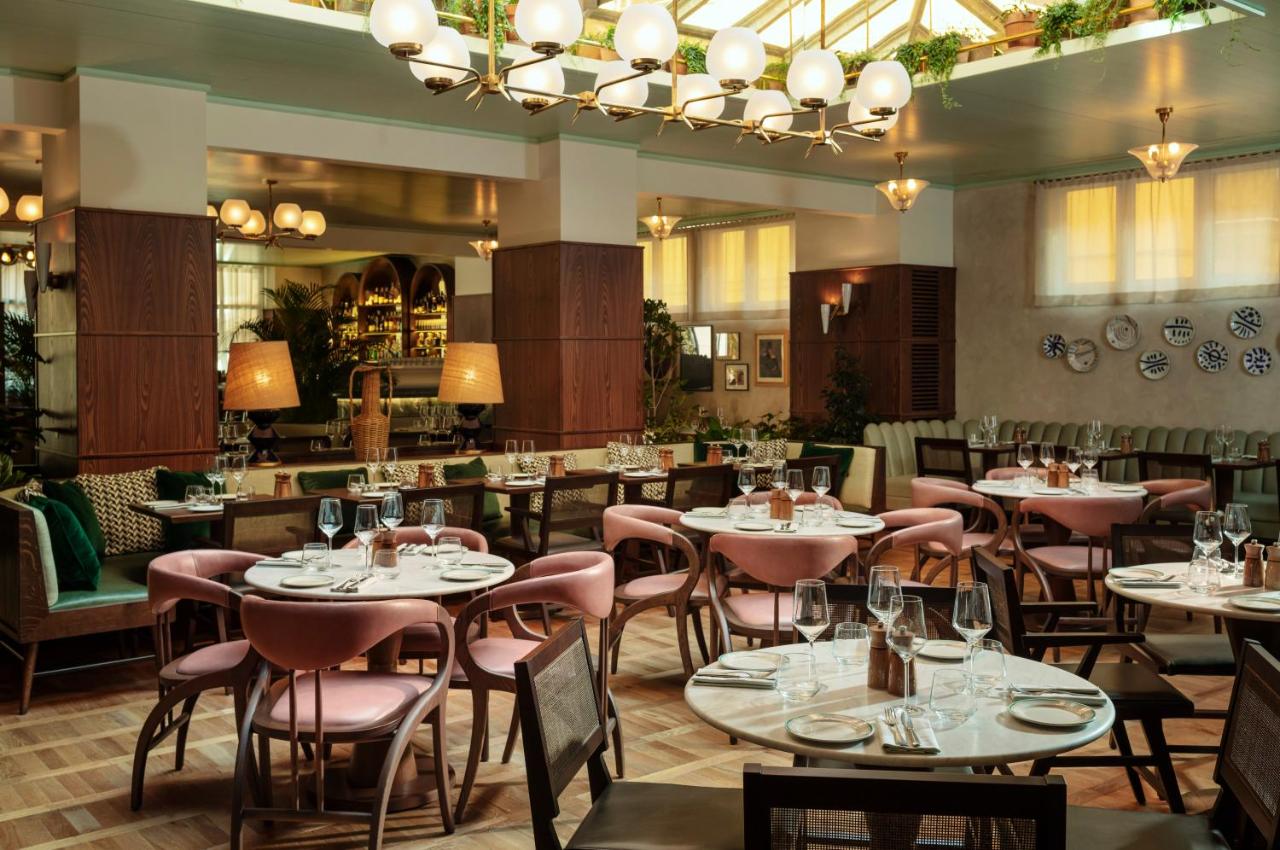 een restaurant met tafels en stoelen en een bar bij The Hoxton, Rome in Rome +35 foto's