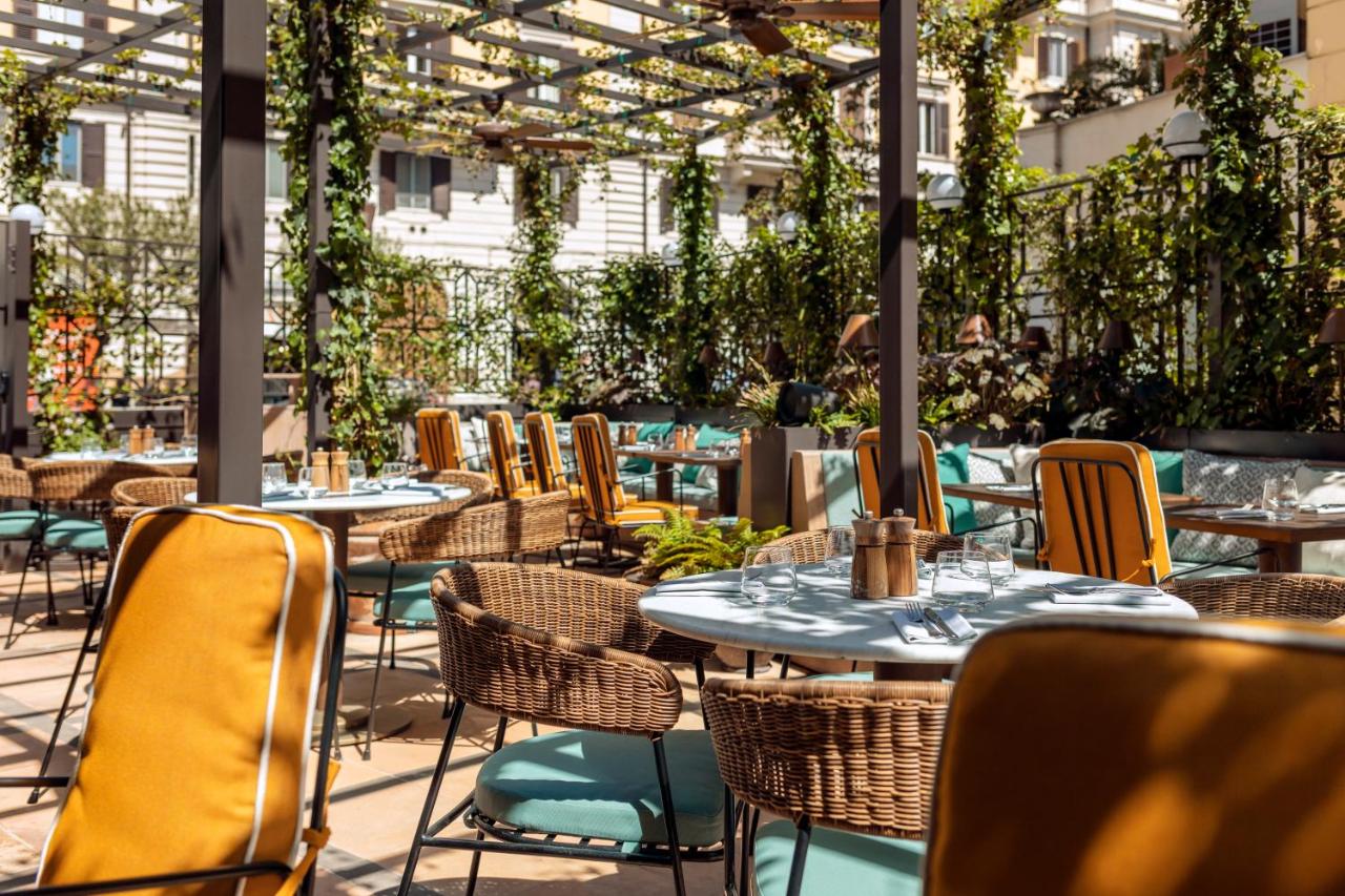 een terras met tafels, stoelen en planten bij The Hoxton, Rome in Rome